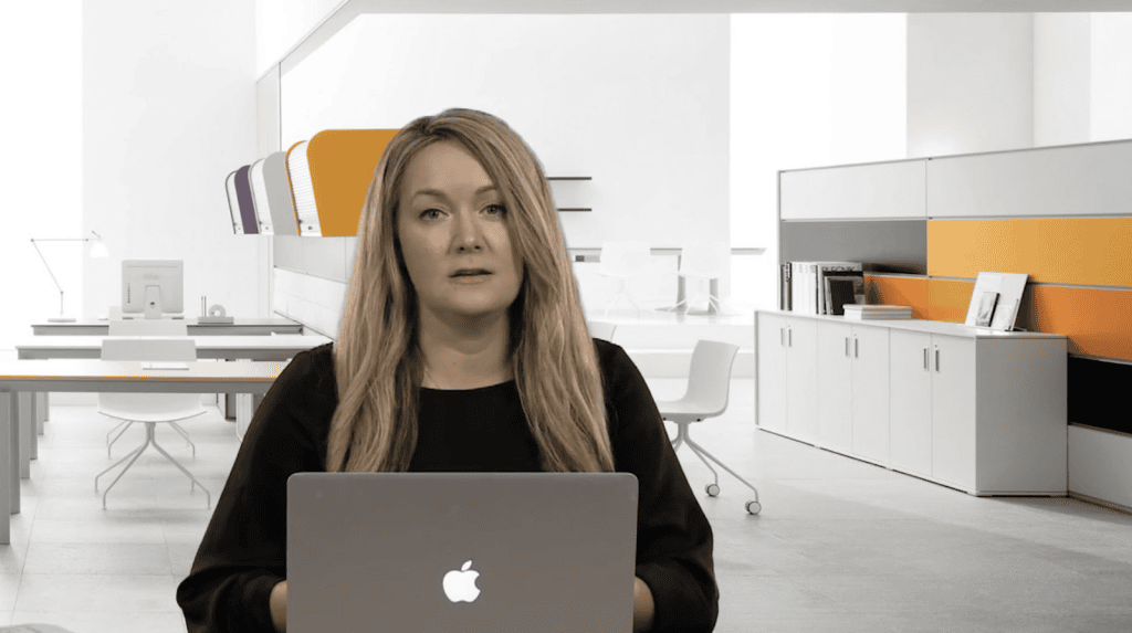 Businesswoman working on a laptop in a modern office setting.