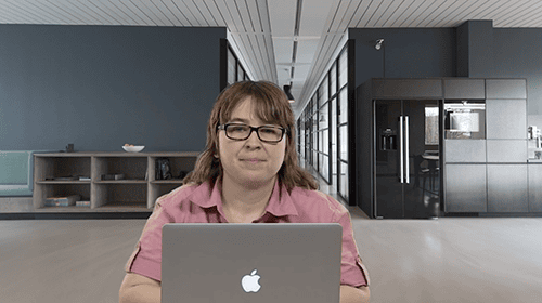 Woman working on a laptop in a modern office environment.